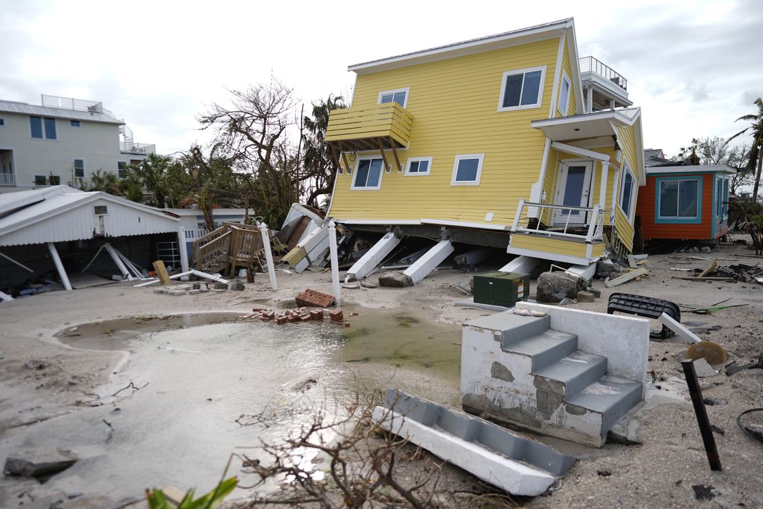 A house, center, lies toppled off its stilts after the passage of Hurricane Milton, alongside an empty lot where a home was swept away by Hurricane Helene, in Bradenton Beach on Anna Maria Island, Florida, on October 10.